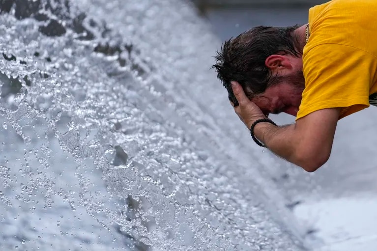 Un hombre se refresca en una fuente durante altas temperaturas en Belgrado, Serbia, el jueves 13 de julio de 2023. (AP Foto/Darko Vojinovic)